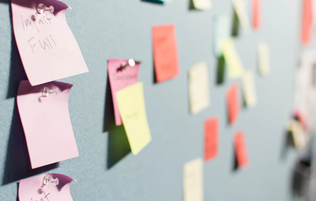 Notas adhesivas organizadas durante una sesión de ideas y prioridades